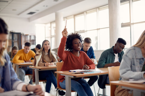 Student-raising-hand-in-classroom-Adobe-Stock-scaled.jpeg