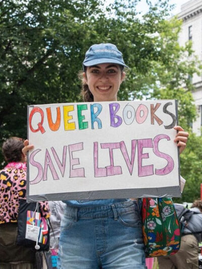 Protestor holding LGBTQ+ positive sign