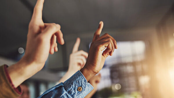 A generic image of hands pointing to the air in a classroom