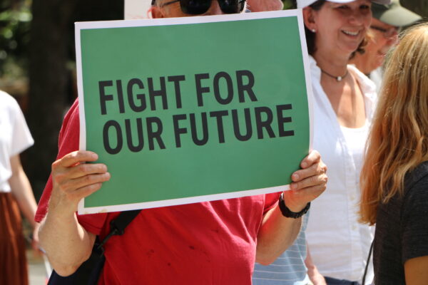 person holding sign that says fight for our future