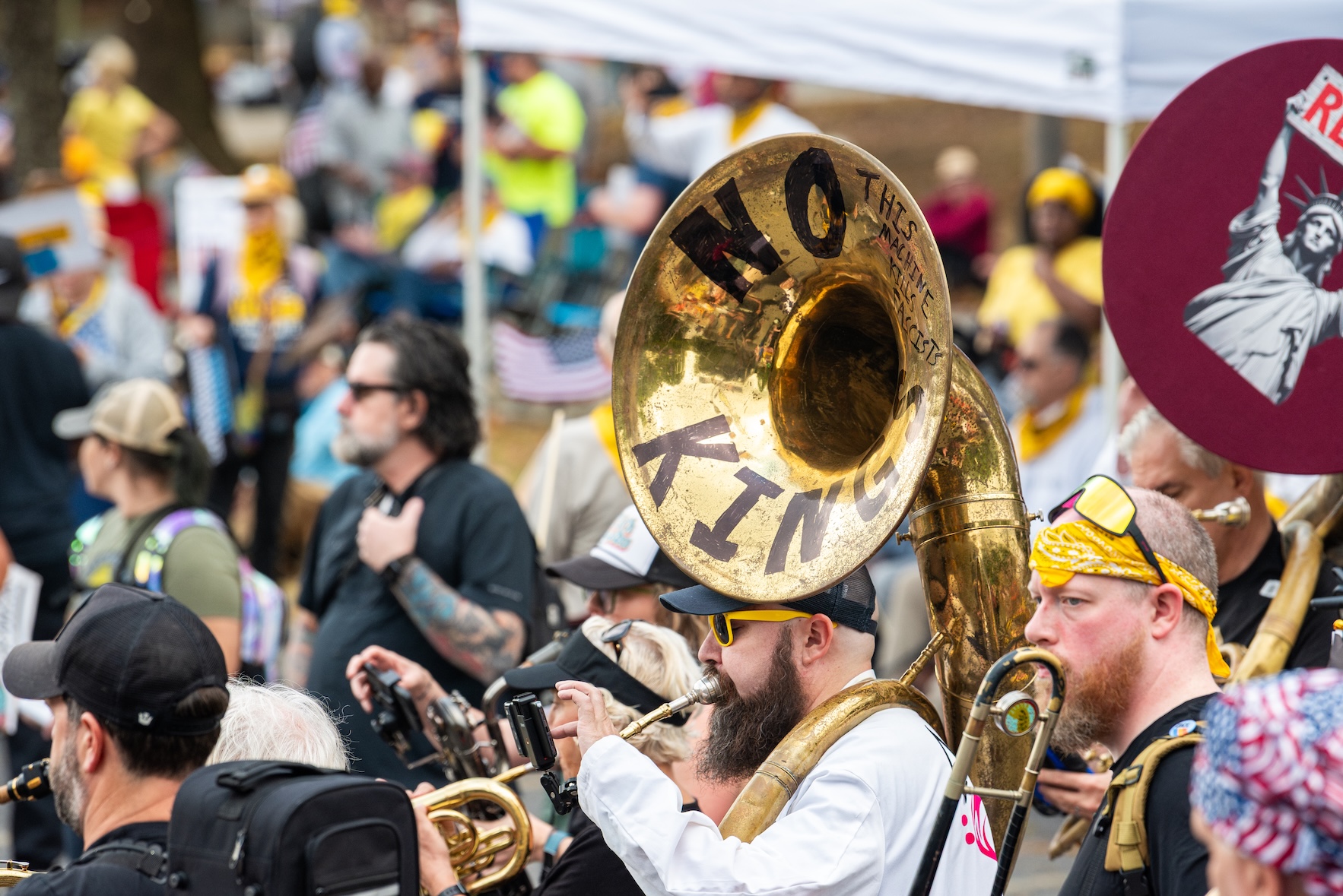 A shiny tuba has the words No Kings on its bell as a band plays amid the crowd at the October 18, 2025 No Kings rally at the Atlanta Civic Center.