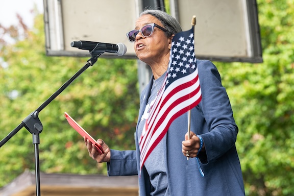 ACLU of Georgia's Executive Director Andrea Young addresses the crowd while waving an American flag at the October 18, 2025 No Kings Rally at the Atlanta Civic Center.