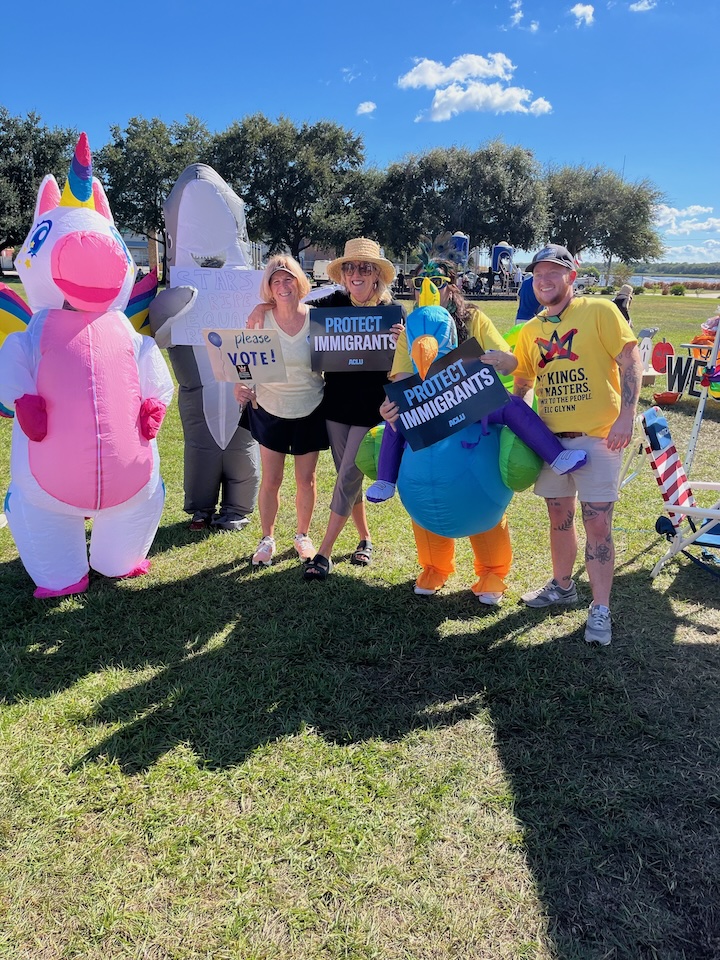 Rally goers in inflatable animal costumes and others holding signs at the October 18, 2025 No Kings Rally in Glynn County, Georgia.