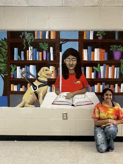 Deepali Patel with disability awareness mural