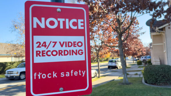 Photo of a notice sign alerting a neighborhood to the use of Flock cameras.