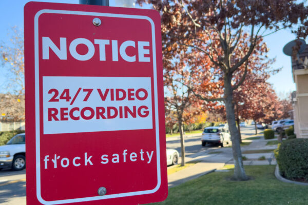 Photo of a notice sign alerting a neighborhood to the use of Flock cameras.