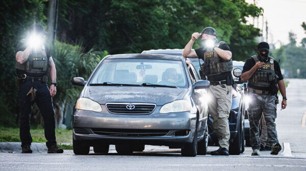 Federal law enforcement searching a vehicle.