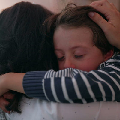 Photo of a child hugging an adult.