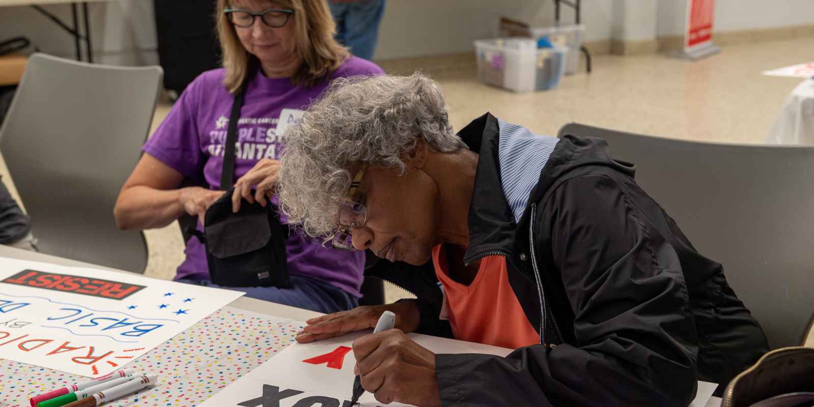 Woman making protest sign at sign making party 