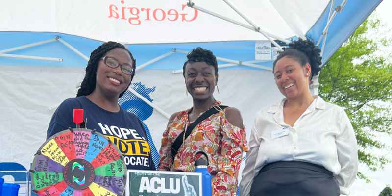 Three staffers at ACLU of Georgia's booth during Sine Die block party 2025