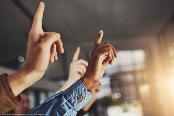 A generic image of hands pointing to the air in a classroom