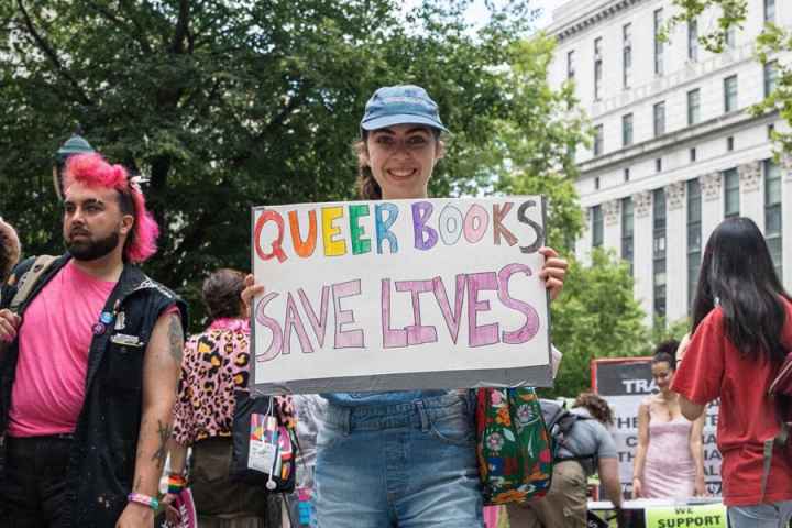 Protestor holding LGBTQ+ positive sign