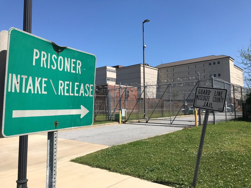 Sign reading "Prisoner Intake/Release" pointing towards building of prison
